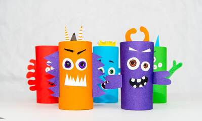 Wall Mural - Halloween decoration. DIY and kids creativity concept. Monsters from toilet rolls and colored paper on a white table.