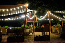 A Gazebo Decorated With Garlands On A Warm Summer Evening