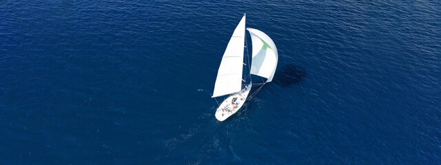 Wall Mural - Aerial drone ultra wide panoramic photo of beautiful sailboat with white sails cruising deep blue sea near Mediterranean destination port