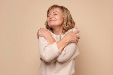 Senior Caucasian Woman Hugging Oneself Happy And Positive, Smiling Confident