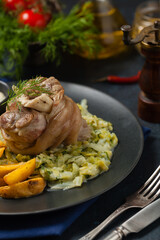 Wall Mural - Boiled knuckle, served with cabbage and baked potatoes. Front view. Darkblue background. Dark mod.