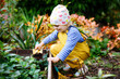© Irina Schmidt - Adorable little toddler girl working with shovel in domestic garden. Cute child learn gardening, planting and cultivating vegetables in domestic garden. Kid with garden tools. Ecology, organic food.