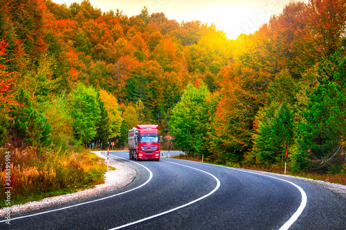 road in autumn forest. Highway view in autumn. big truck is driving on highway between trees. Autumn in October and November. colorful autumn highway view. Uludag mountain, Bursa.