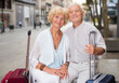 © JackF - Romantic mature family pair with a traveller bags relaxing on a stone bench outdoors