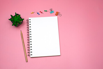 Wall Mural - Flat lay, Top view text and leave a message concept on pink table desk background with blank notepad and green plant, pencil and stationeries, copy space