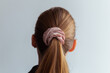 © Jan - Close-up of a natural blonde hair, tied up in a ponytail by pink velvet scrunchie, back view