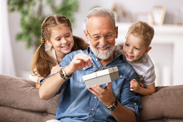 Wall Mural - grandfather and grandkids opening present.