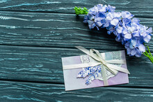 Top View Of Wooden Green Background With Blue Flowers And Envelope