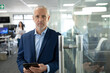 © wavebreak3 - Portrait of senior businessman holding digital tablet at modern office