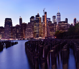 Autocollant - Night photo of glowing skyscrapers and a view of Manhattan Bay. Long duration. Vertical panorama. The splendor of the city at night.