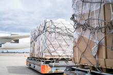 Air Freight Cargo On Dolly Trailer Waiting To Be Loaded Onto Aircraft