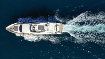 Aerial drone photo of luxury yacht with wooden deck cruising deep blue Aegean sea near island of Mykonos, Cyclades, Greece