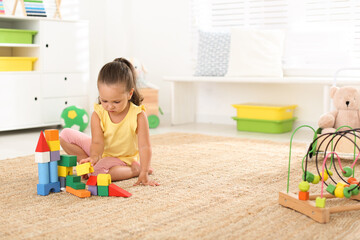 Poster - Cute little girl playing with colorful blocks on floor indoors, space for text. Educational toy