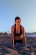 © Wander - young caucasian woman doing stretches and yoga exercises on the beach on sun rising.