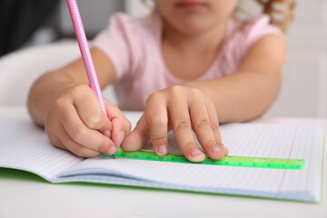 Canvas Print - Little girl drawing with ruler and pencil at table, closeup. Doing homework