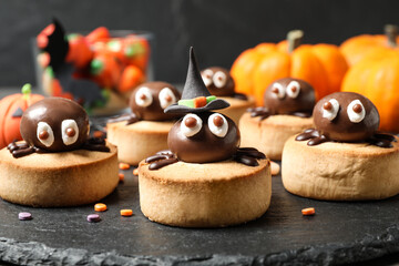 Sticker - Delicious biscuits with chocolate spiders on slate plate, closeup. Halloween celebration