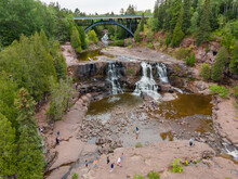 Aerial View Of Gooseberry Falls, MN Showing Waterfalls, Fir Trees And Bridge On Summer Day.