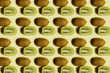 Wall Mural - Kiwi pattern. Repetition of kiwi halves on a yellow background. Colorful food background. Fruit pattern. Healthy food concept.