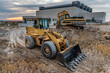 Two excavators at a construction site performing earthmoving