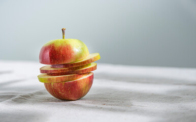 juicy green red apple cut into slices on a natural linen tablecloth