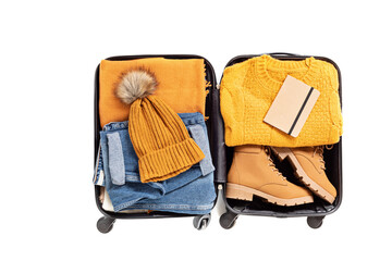 Flat lay with open suitcase with casual clothes for autumn, winter vacations over white background