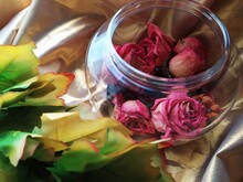 Dry Pink Roses In The Glass Jar On The Table With Leaves