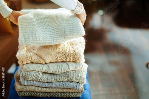 Fotografía Closeup on elegant woman prepare sweaters pile for storage