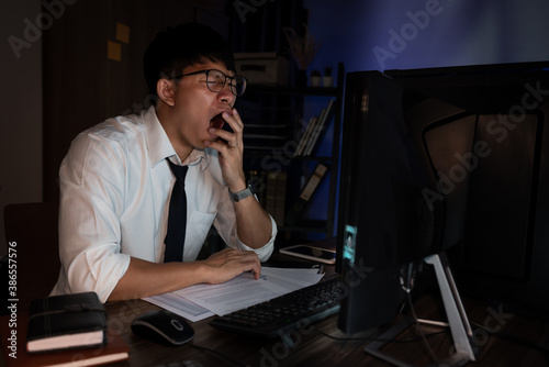 Fotomural Businessman workaholic sit at the computer working late at night yawn tired and sleeping in the office,Hard work in the later time concept