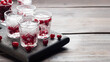 Stacks of vodka and cranberries on a wooden stand and background. Copy of the space. Bar alcoholic beverage tincture.