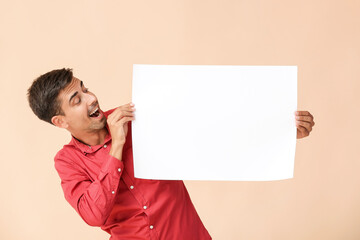 Surprised young man with blank paper sheet on color background