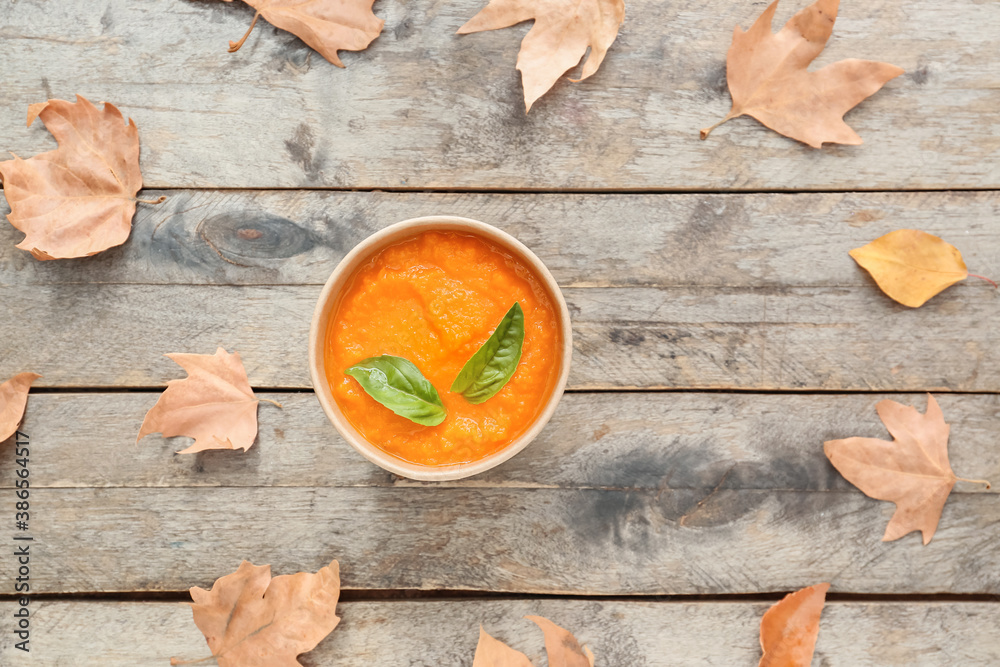 Tasty pumpkin cream soup in cup on table