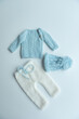 © develi - Various colors and types of cotton clothing, knitted newborn clothes and newborn hats on a white background.