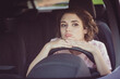 © deagreez - Photo of bored unhappy cute young woman lady driver sleepy sit put head hands steering wheel alone car drive home traffic jam bad news upset expression wear beige t-shirt inside auto salon