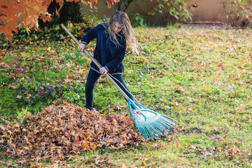 cute little girl playing collecting leaves in the garden