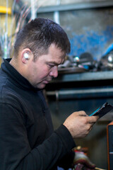 Wall Mural - Close-up portrait of a man in the workplace with a mobile phone