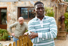 Portrait Of Displeased Man Ignoring Male Neighbor After Quarrel