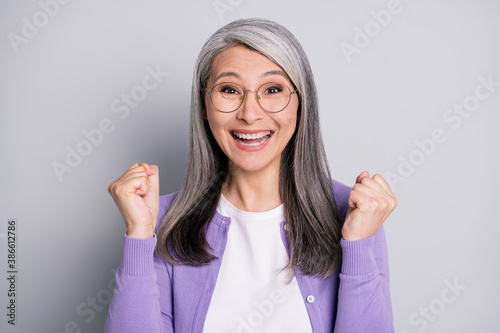Fotomural Photo of funny lovely retired lady raise up fists excited surprised triumphant b