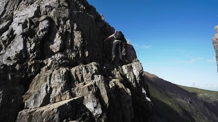 Canvas Print - Backpacking man climbing a dangerous rocky mountain