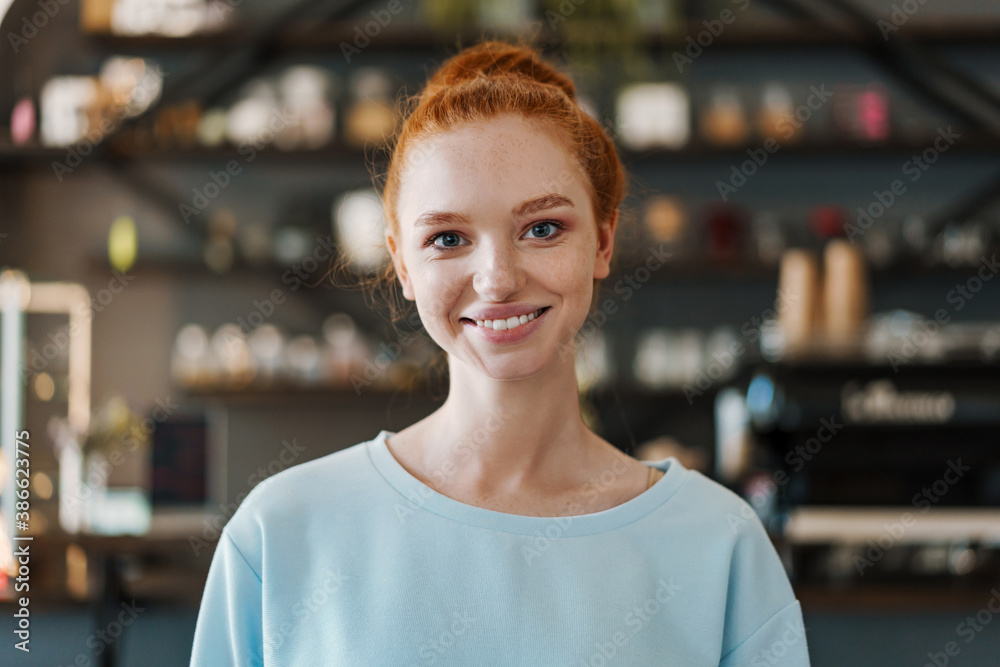 Smiling young woman standing at the coffee shop - obrazy, fototapety, plakaty 