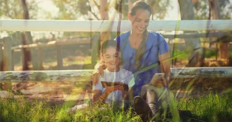Poster - Woman and daughter using electronic devices in countryside against grass moving in the wind