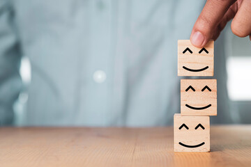 Poster - Select emotion or mood concept , Hand holding and stacking smile face  or happy face which print screen on wooden cube block.