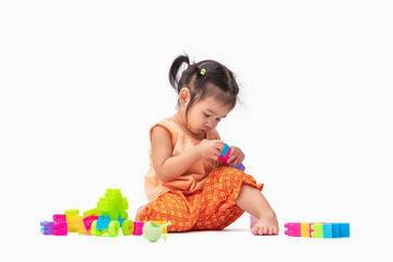 Portrait asian child girl in Thai traditional dress sit and play colorful plastic blocks or toy happily isolated on white background