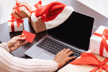 Xmas Shopping. Black lady using laptop and credit card