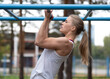 © junky_jess - Athletic blond beautiful caucasian woman doing chin ups exercise on the sports ground outdoor in summer, side view, close up, selective focus