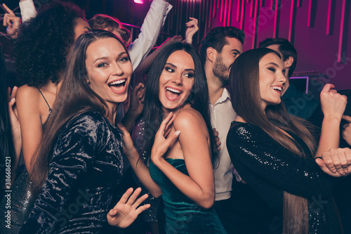 Photo of cheerful laughing happy beautiful girls wearing fashionable dress dancing at party in night club together celebrating new year with friends