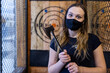© Mat Hayward - Teenage girl holding axe at an axe throwing range with target behind her