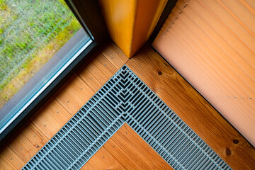 Heating in the floor of the cottage. Ventilation grilles in the floor. Maintaining a favorable microclimate in the room. Heating and ventilation systems.