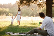 © Andriy Medvediuk - father, mother and son blow soap bubbles in the park together on a sunny summer day. happy family having fun outdoor