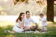 © Andriy Medvediuk - father, mother and son in the park together on a sunny summer day. happy young family having fun outdoor