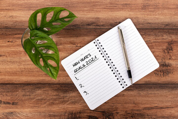 Wall Mural - 2021 New Year's Goal text on notepad with pen and green monstera plant